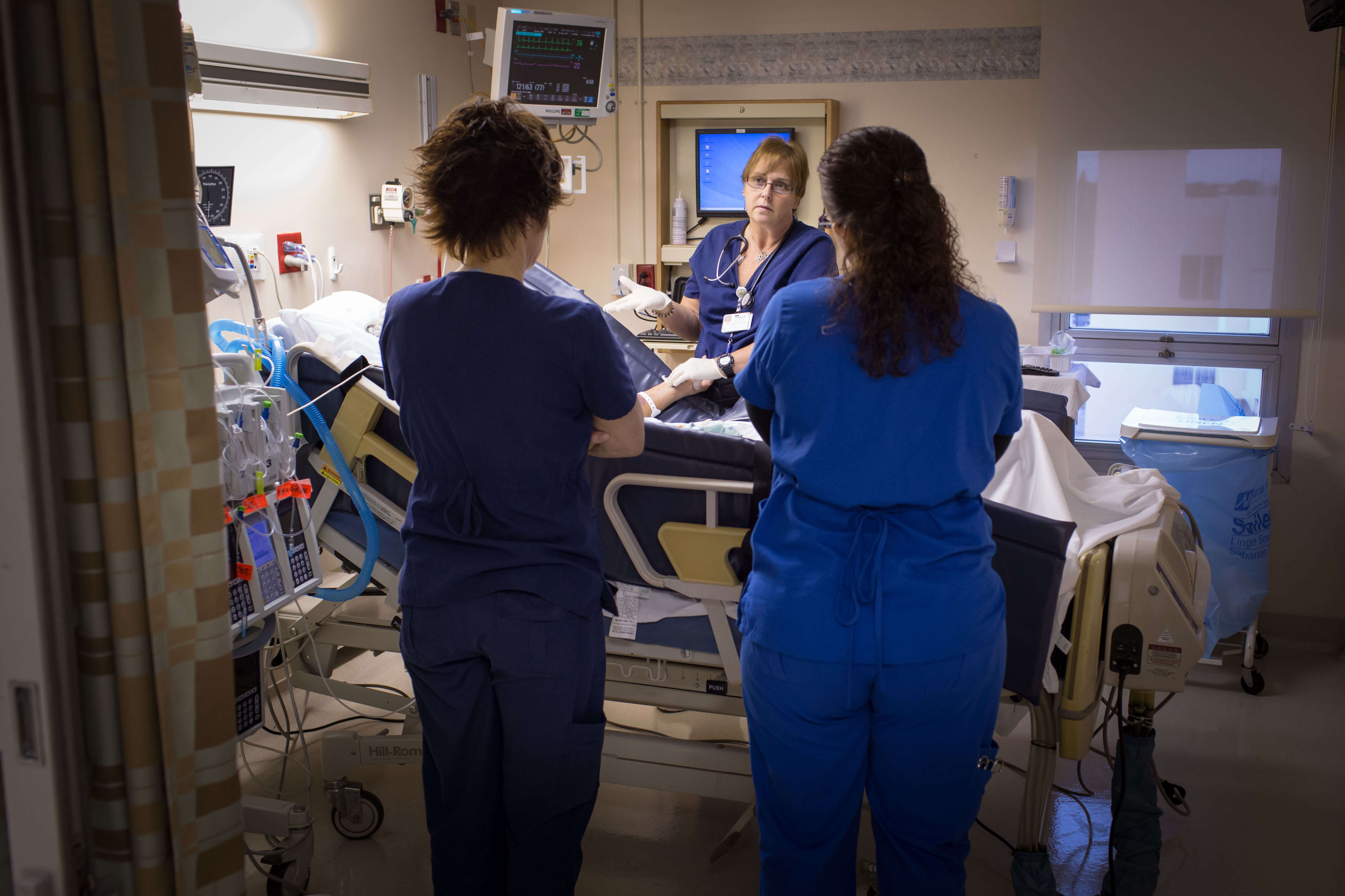 Nurses working on patient in hospital bed